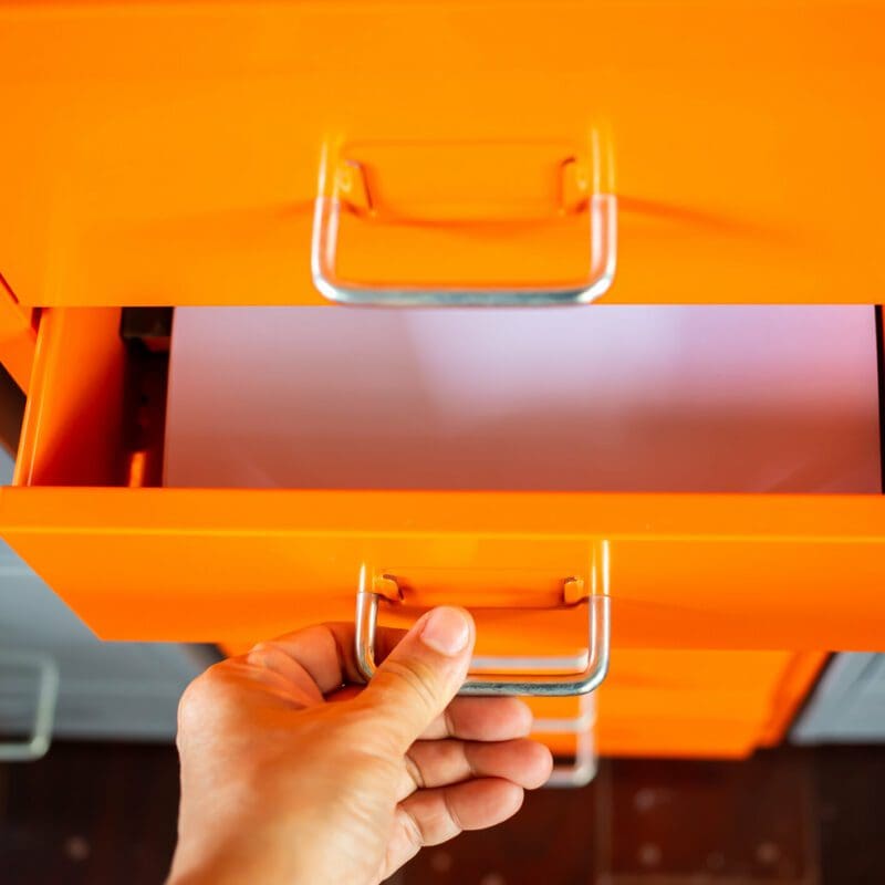 Woman’s hand opening drawer of orange metal colour filing cabinet, White papers for write letter, Administration and storage, Close up shot, Selective focus, Stationery, Business concept orange filing cabinet
